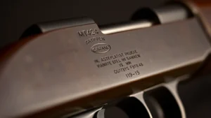 Close-up of vintage M1 Garand rifle receiver showing manufacturer markings and serial number details, professional studio lighting, shallow depth of field emphasizing metal engraving